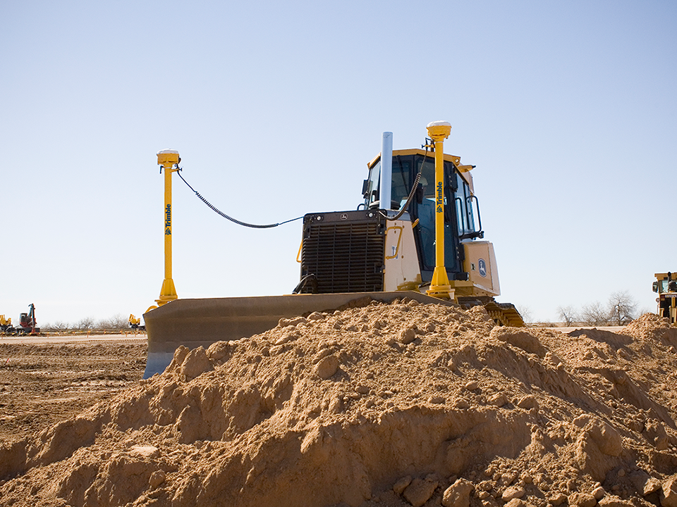 Dozer using site positioning solutions Trimble technology on a construction site. Solutions