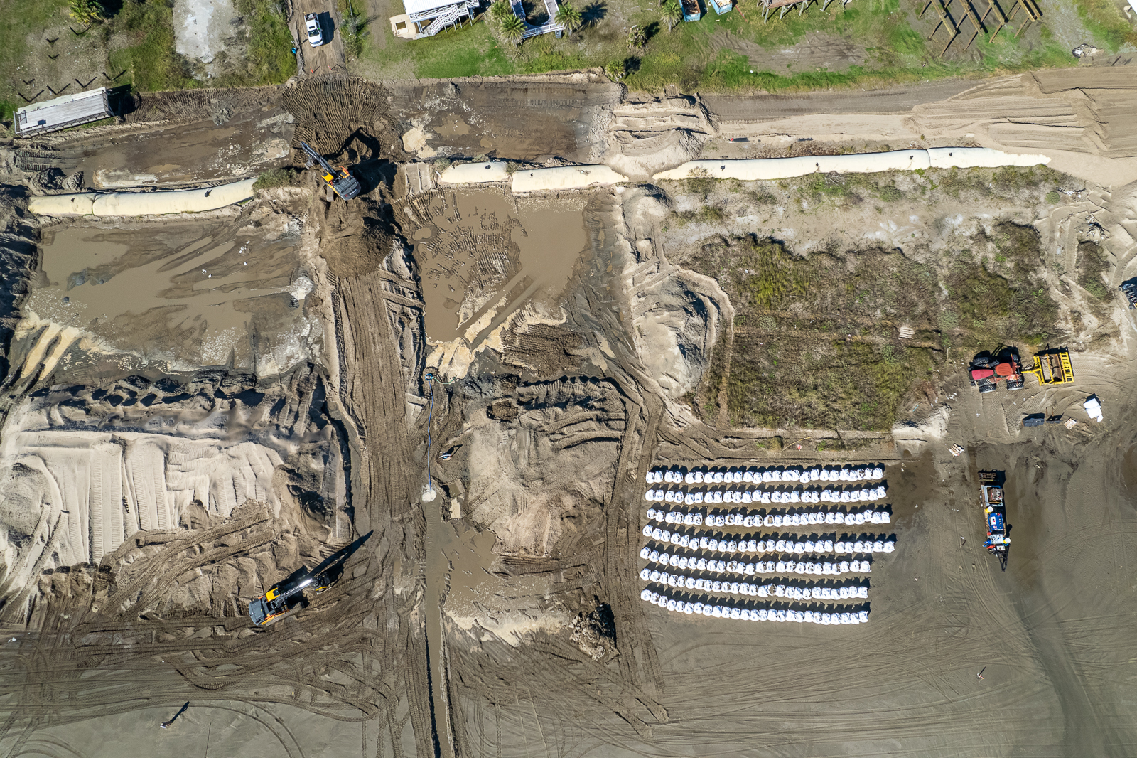 Grand Isle construction site aerial view showing construction equipment enabled with Trimble technology. Machine Control Systems